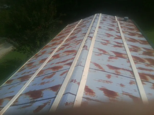Rusted metal roof panels with new wood purlins before replacement — Storm Damage Roof Repair in Amesville by Roofing Brothers